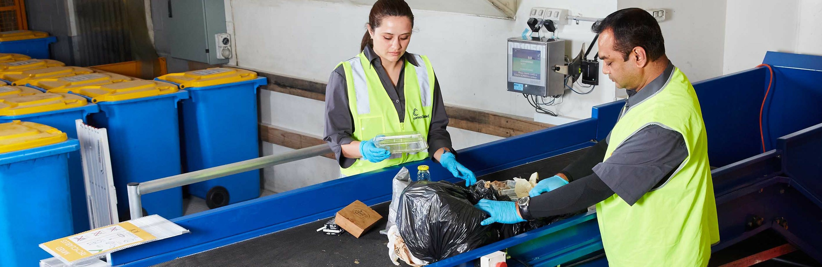 Staff sorting recycling on a conveyor belt